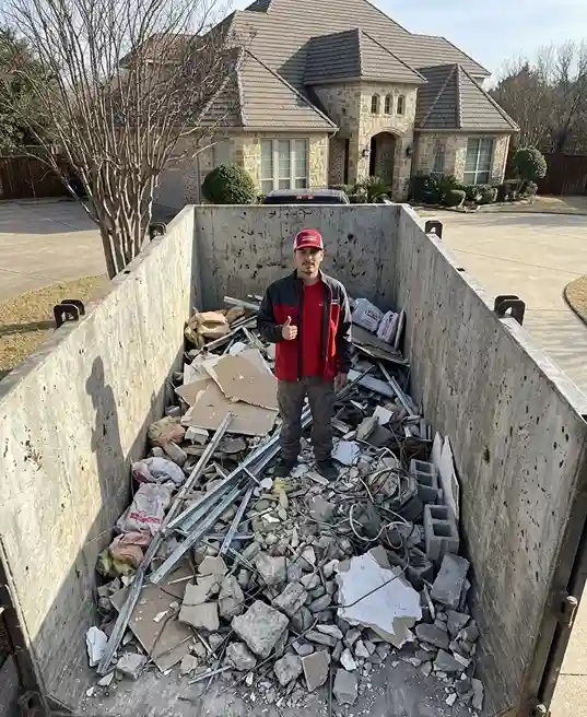 roll off concrete dumpster filled with heavy debris at construction site